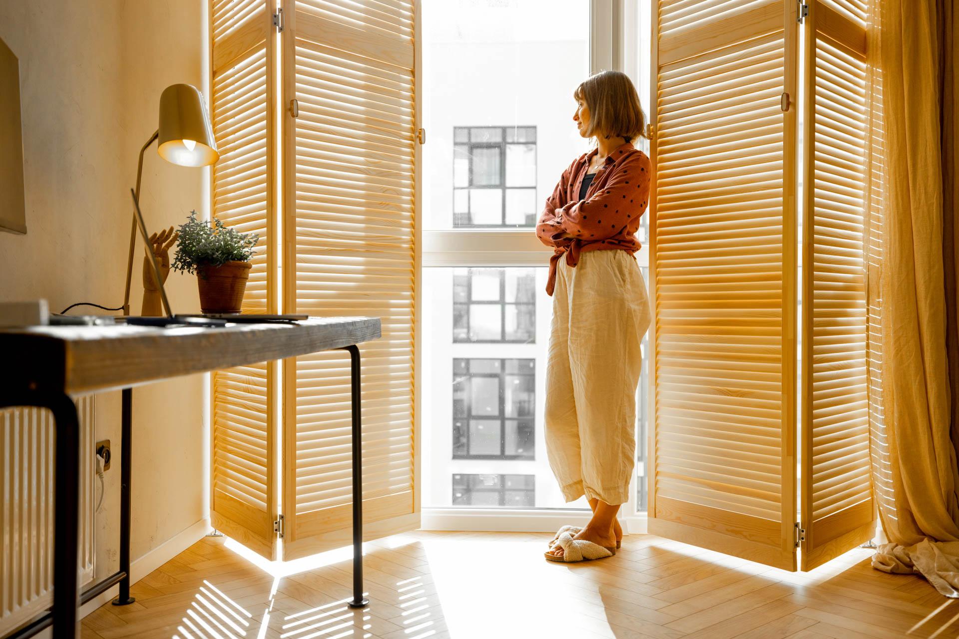 Woman Stands Alone By The Window Blinds At Home